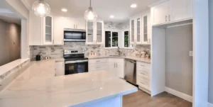 Bright and modern kitchen with white cabinets, sleek countertops, stainless steel appliances, and a neutral backsplash. The open layout creates a welcoming space for cooking and entertaining. Ready to upgrade your kitchen? Start planning your remodel today!