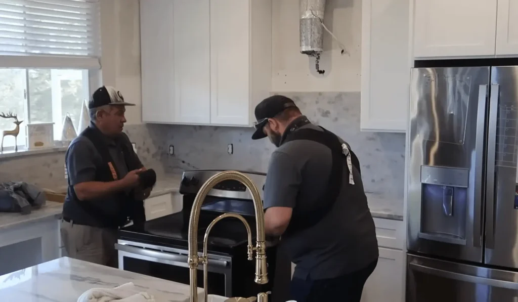 Two professional contractors installing a kitchen stove and working on remodeling a kitchen. Hire a contractor to ensure your kitchen renovation is done right the first time.