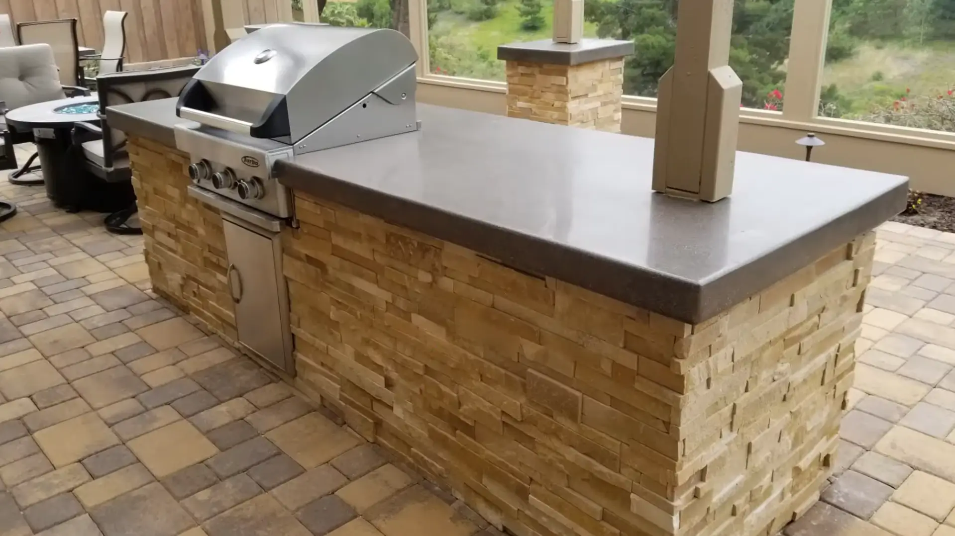 A sleek outdoor kitchen setup with a built-in grill and stone countertops, crafted by Kitchen and Bath Remodel Albuquerque. Transform your outdoor space today!